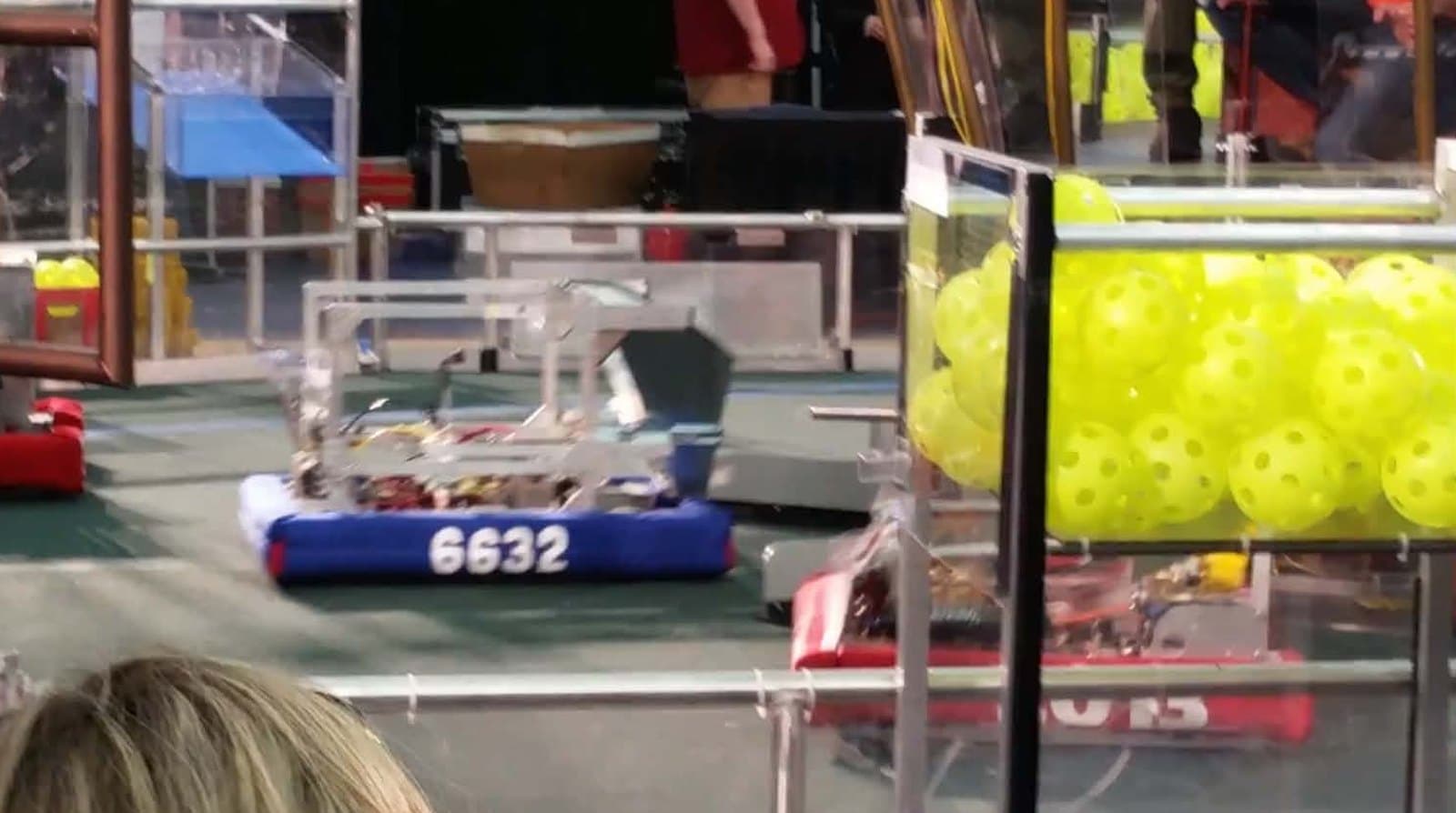Team 6632's robot on the 2017 FIRST STEAMWORKS field, its blue bumper numbered 6632, beside a bin of yellow fuel balls